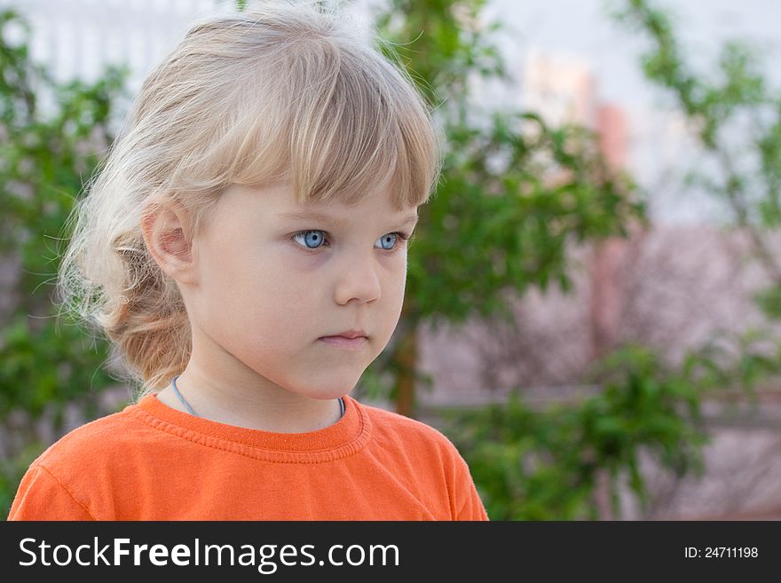 Thoughtful blue-eyed girl in orange t-shirt. Thoughtful blue-eyed girl in orange t-shirt