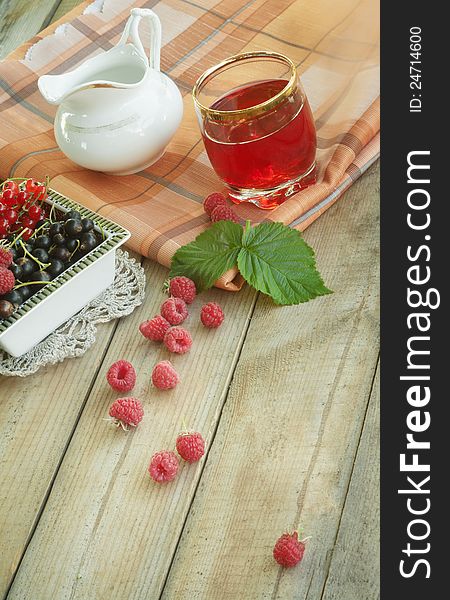 Fresh fruit juice on a table with raspberry