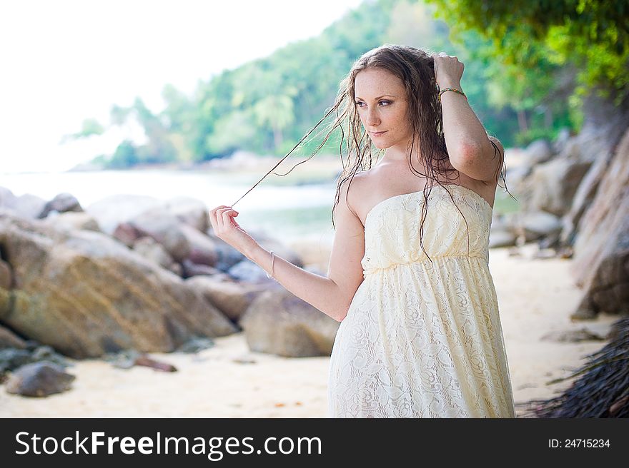 A beautiful young girl in white dress stroking her hair