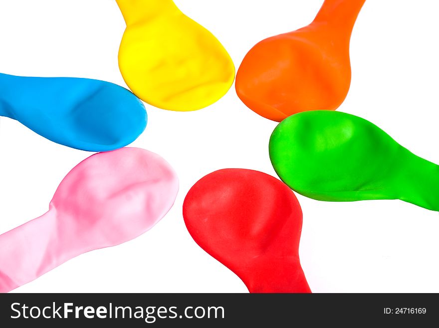 A set of rainbow-colored uninflated balloons laid down star-shaped (isolated on white). A set of rainbow-colored uninflated balloons laid down star-shaped (isolated on white)