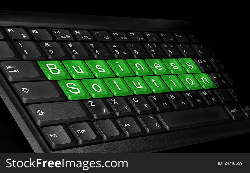 Laptop keyboard and text ''Business solution'' colored green.