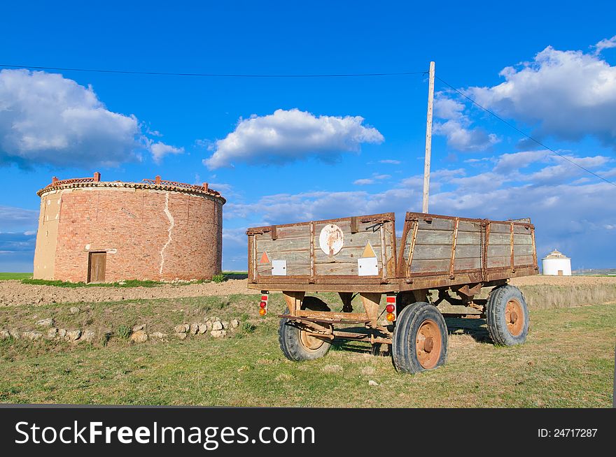 Old and rusty wooden trailer in the field with dovecotes. Old and rusty wooden trailer in the field with dovecotes.