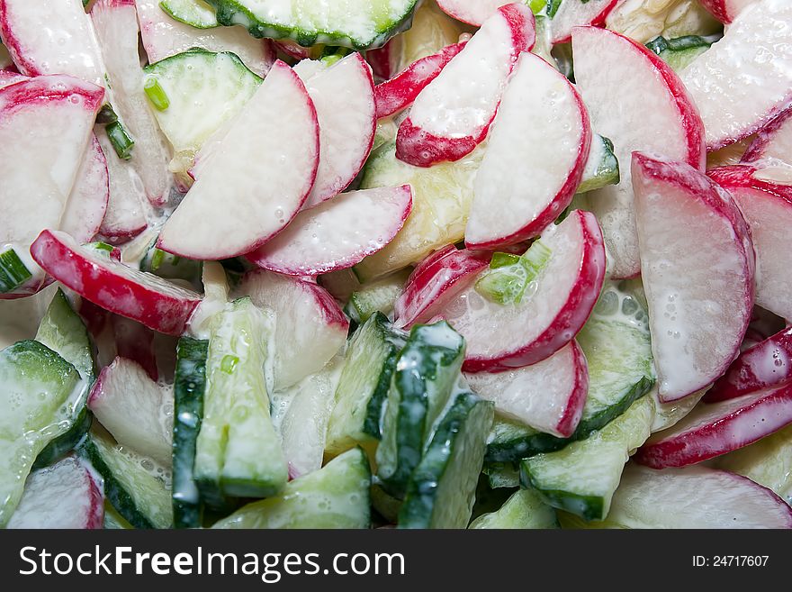 Salad of cucumber, radishes and onions closeup.