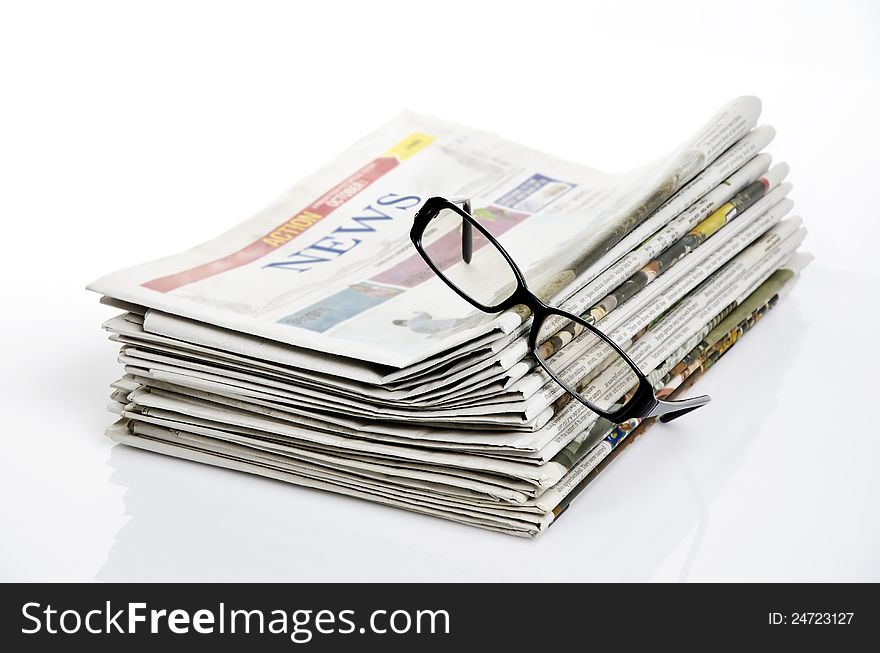 Bird eye view of glasses on newspapers against white background. Bird eye view of glasses on newspapers against white background