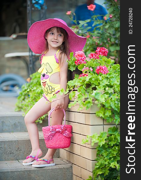 Photo a cute little girl in hat posing with beautiful flowerbeds. Photo a cute little girl in hat posing with beautiful flowerbeds