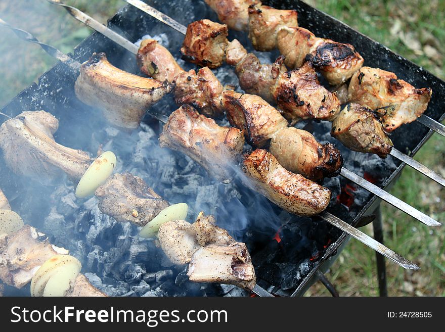 Tasty grilled meat on skewers close-up