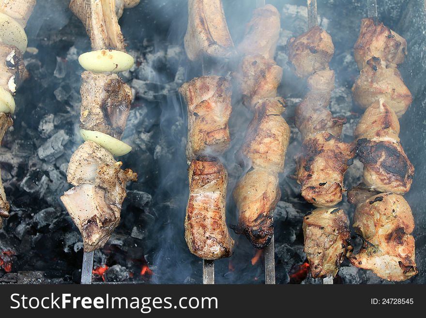 Tasty grilled meat on skewers close-up