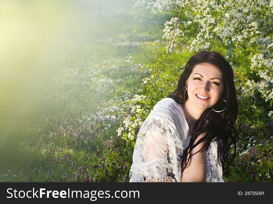 Image of a beautiful girl in the park against the backdrop of flowering trees