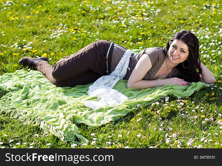 The image of a beautiful girl lying on the grass with flowers