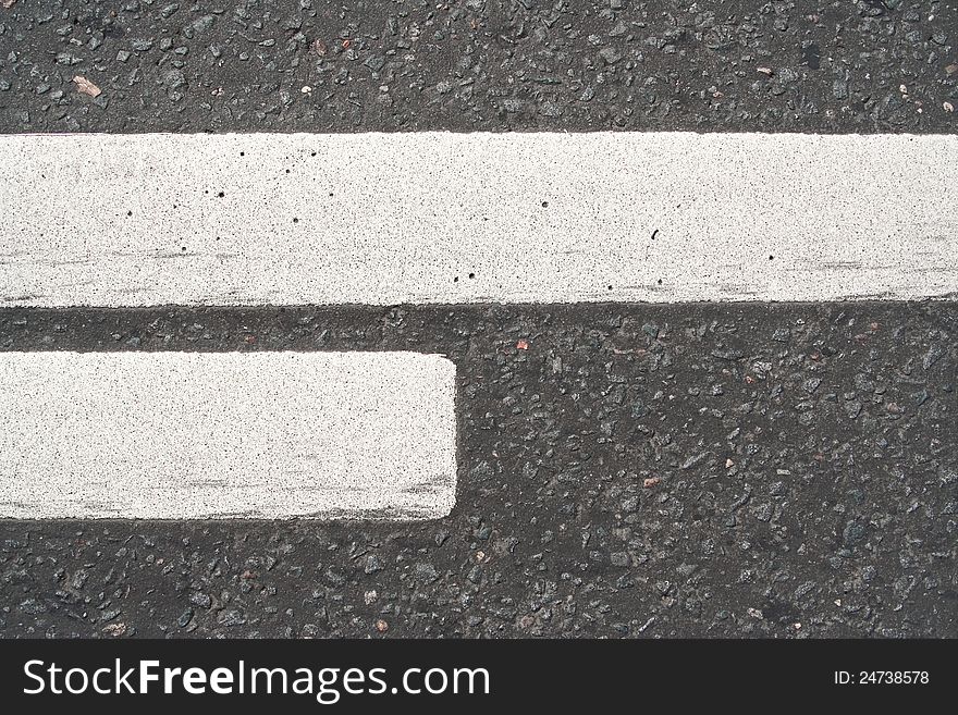 Road asphalt with white markings. The texture of the background. Road asphalt with white markings. The texture of the background