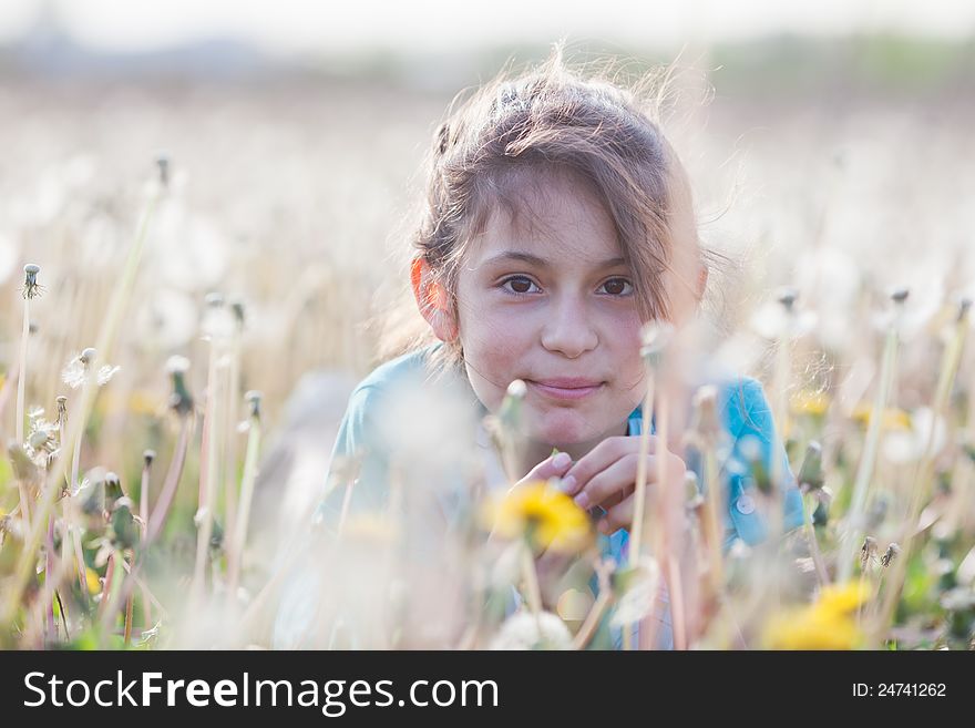 Beautiful girl in a dandelion meadow