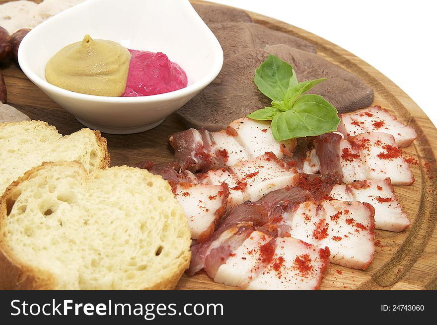 Wooden dish with bacon and sausage on a white background