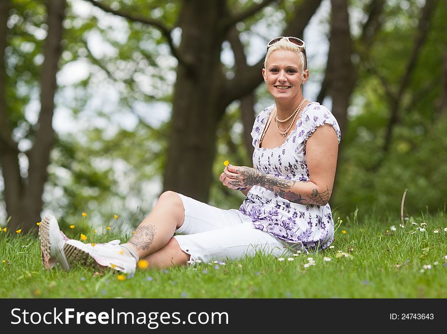 Beautiful Woman Sits In The Grass