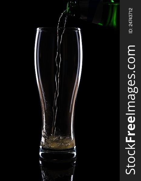 Fresh beer with froth and condensed water pearls on black background. Fresh beer with froth and condensed water pearls on black background