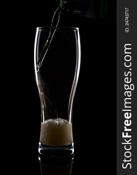 Fresh beer with froth and condensed water pearls on black background. Fresh beer with froth and condensed water pearls on black background