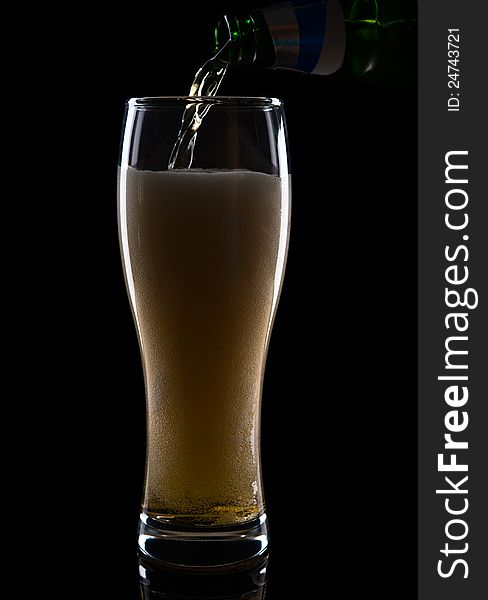 Fresh beer with froth and condensed water pearls on black  background. Fresh beer with froth and condensed water pearls on black  background