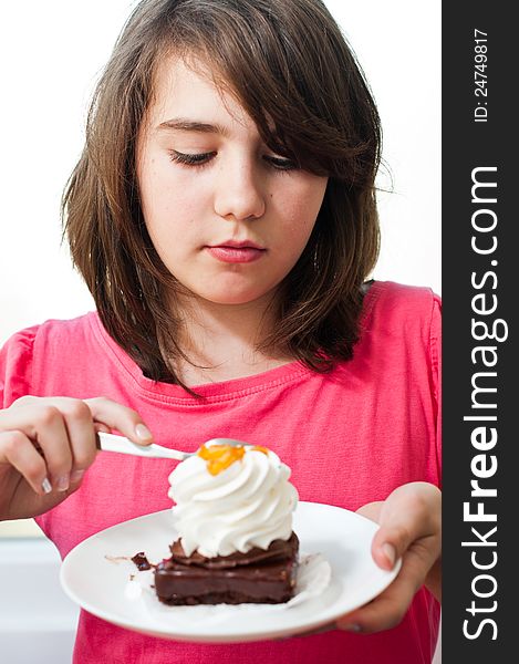 Fun teen girl eating the cake on the white background .Portrait of young woman eating cake isolated on white background