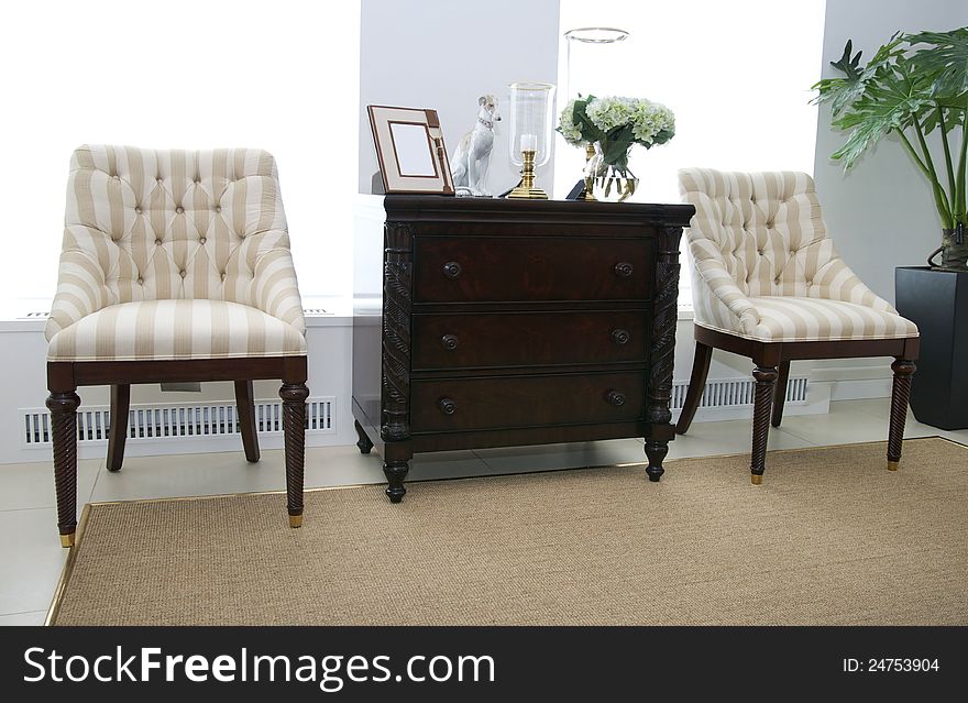 Comfortable upholstered chairs and a coffee table with books