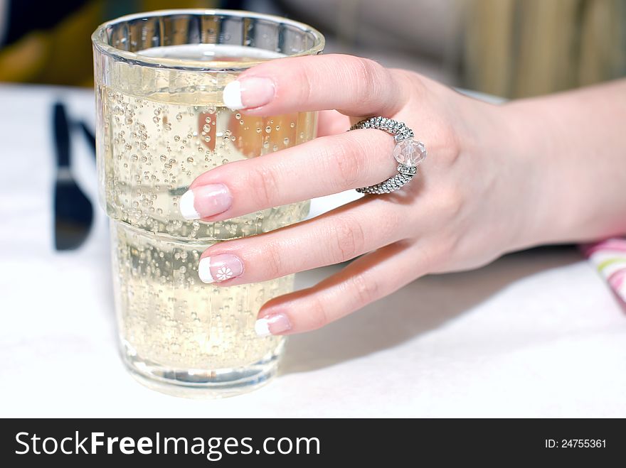 Close up of female hand, holding the glass with sparkling beverage. Close up of female hand, holding the glass with sparkling beverage
