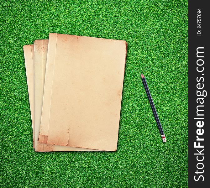 Pencil And Old Book On Green Grass