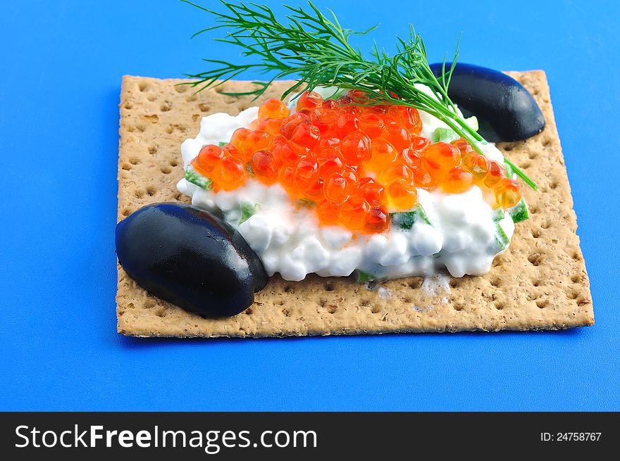 Crackers with cheese, caviar, a sprig of fennel and black olive. Crackers with cheese, caviar, a sprig of fennel and black olive