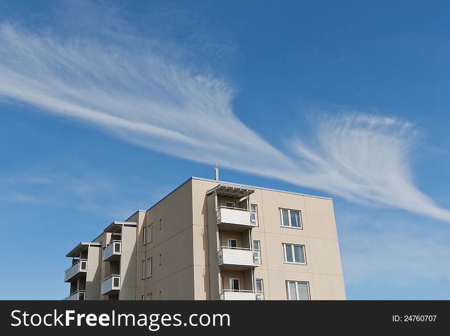 Apartment building and a cloud at blue sky. Apartment building and a cloud at blue sky