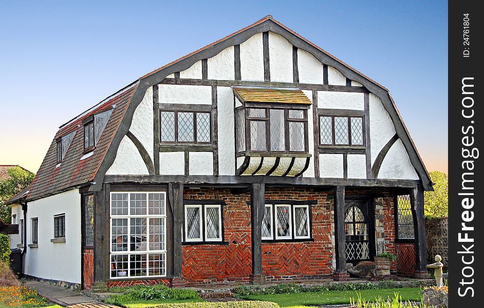 Photo of an old beamed tudor cottage showing herringbone brickwork. Photo of an old beamed tudor cottage showing herringbone brickwork.