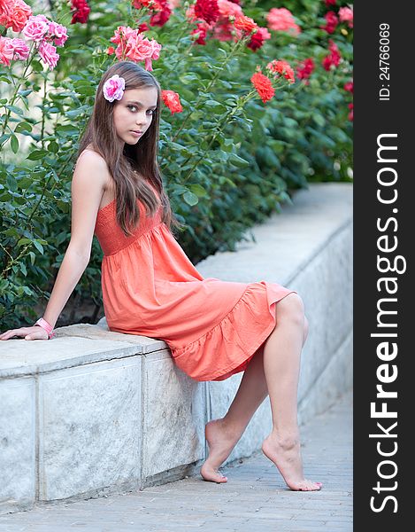 Portrait of beautiful fresh teenager girl with expressive look posing on a background of flowerbeds. Portrait of beautiful fresh teenager girl with expressive look posing on a background of flowerbeds