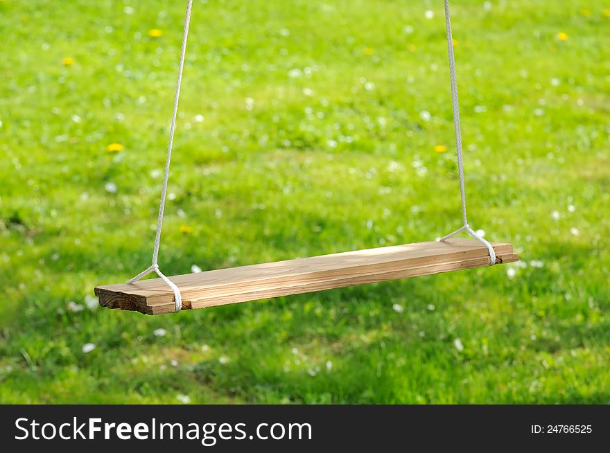 Empty Wooden Swing In The Garden