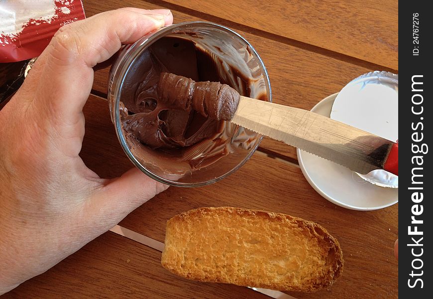 Woman smears the chocolate on the bread