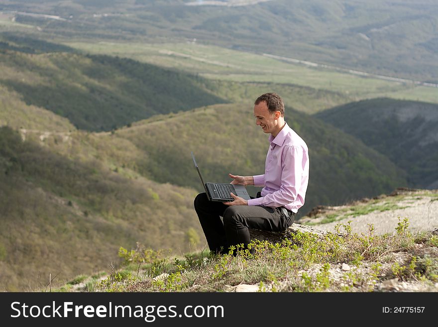 Man writes in notebook sitting on stone. Man writes in notebook sitting on stone