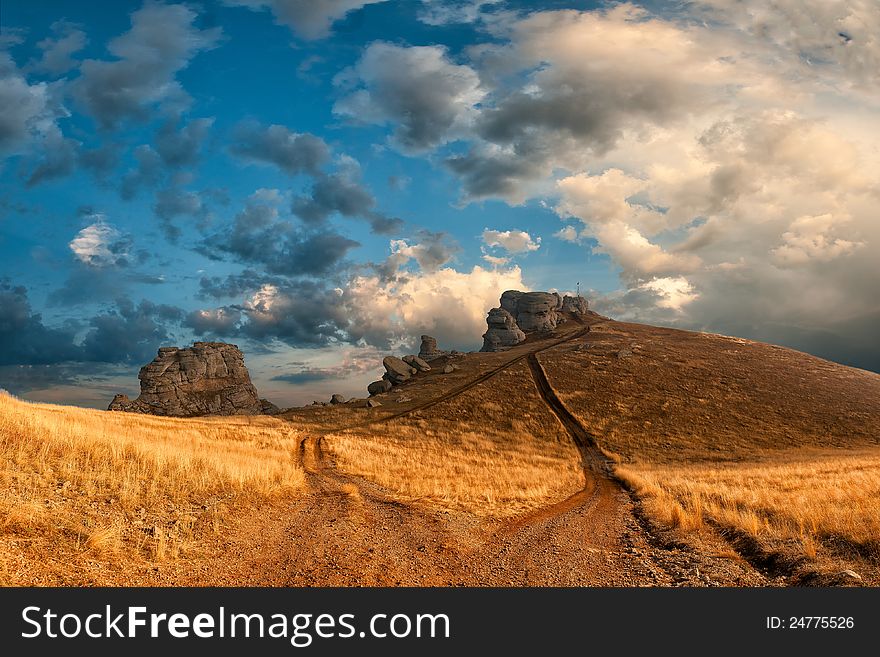 Landscape witn road to the mountains peak and majestic clouds on background