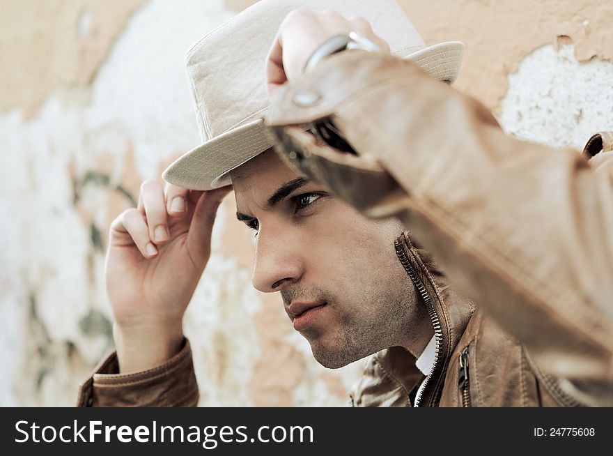 Portrait of a handsome young man with a hat in urban background. Portrait of a handsome young man with a hat in urban background