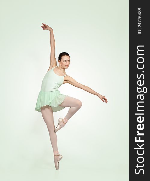 Young beautiful ballerina on a green gradient background. Young beautiful ballerina on a green gradient background