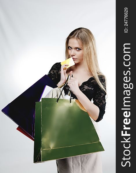 Beautiful girl with a credit card and shopping bags on white background. Beautiful girl with a credit card and shopping bags on white background