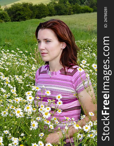 Young woman in wild chamomile is a dreamy expression. Young woman in wild chamomile is a dreamy expression