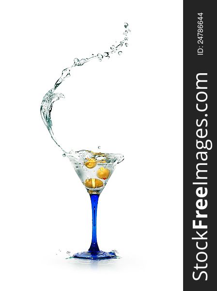 Stylish martini glass with splashing liquid and olives on white background. Stylish martini glass with splashing liquid and olives on white background
