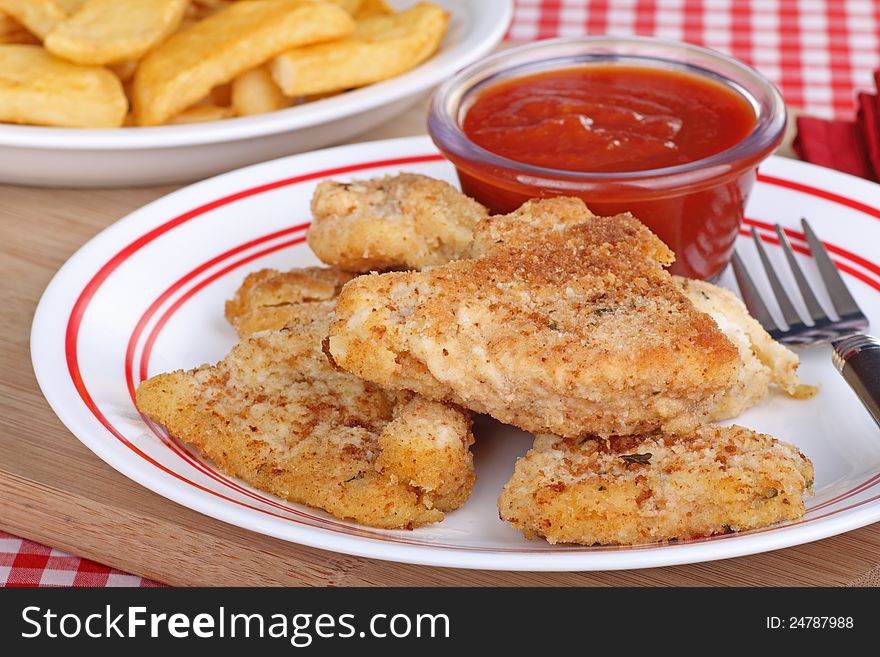 Breaded fish dinner with french fries in background