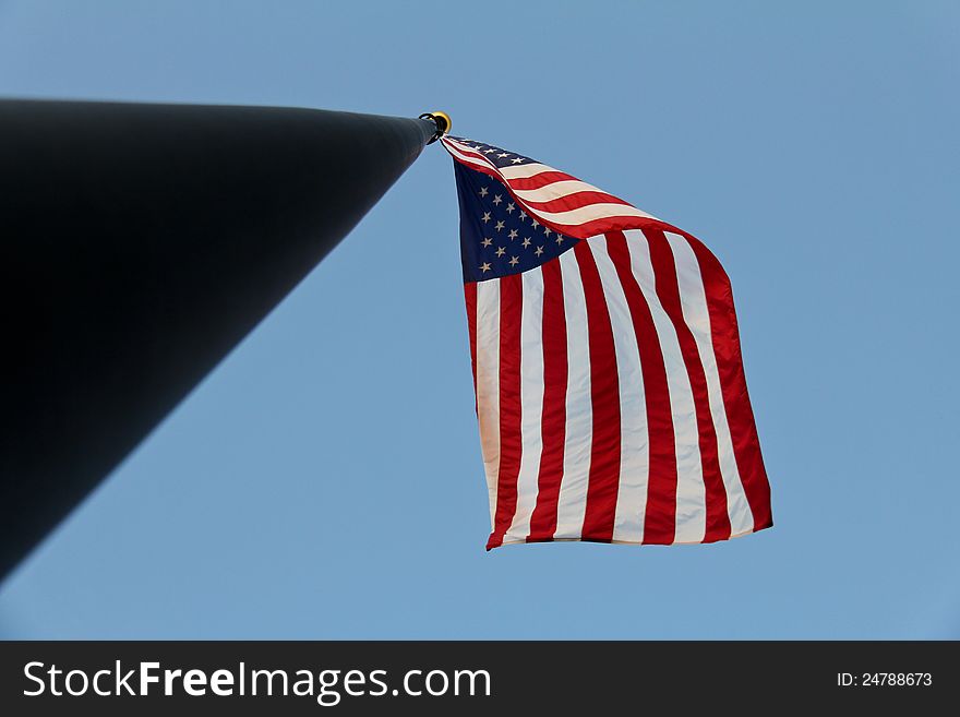 Image of a flag flying on a staff shot from directly underneath. Image of a flag flying on a staff shot from directly underneath