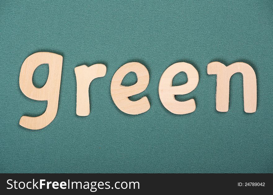 The word Green in wooden letters on a green textured background