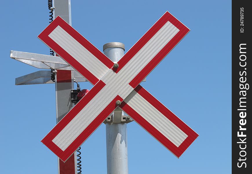 Close-up of an X railroad crossing warning sign against a blue sky. Close-up of an X railroad crossing warning sign against a blue sky.