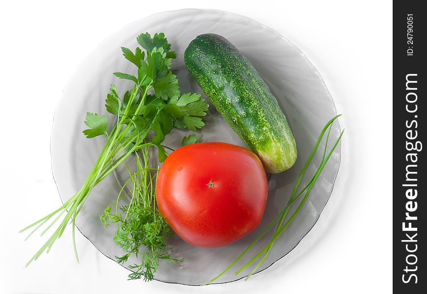 A shot from above of tomato, cucumber, celery, garlic and dill lying on a glass plate;. A shot from above of tomato, cucumber, celery, garlic and dill lying on a glass plate;