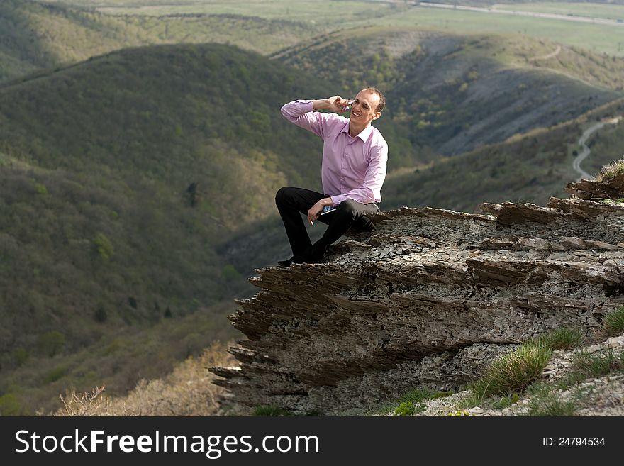 Man with notepad and telephone on mountain
