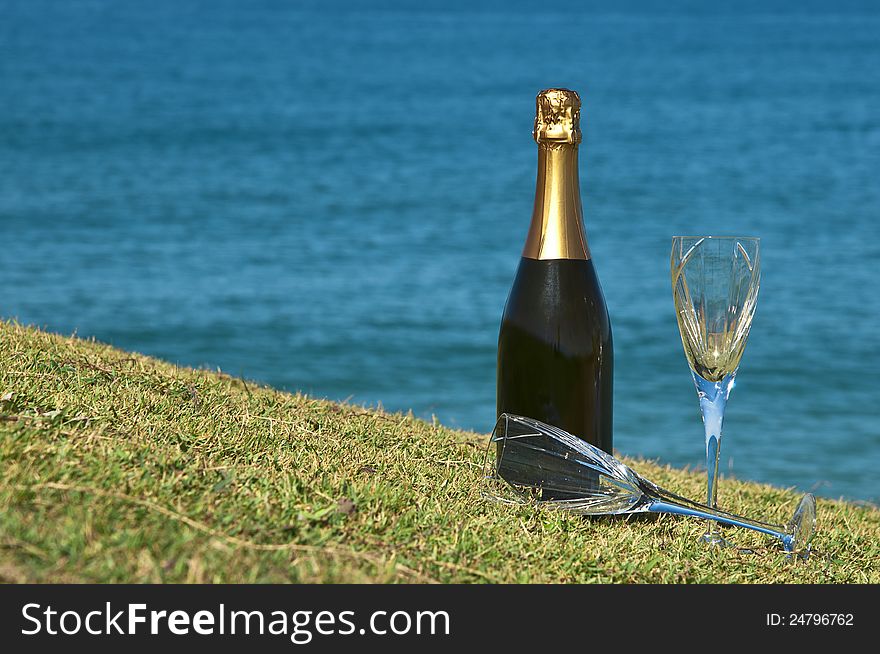 Champagne and glasses on the top of a headland overlooking the ocean. Champagne and glasses on the top of a headland overlooking the ocean.
