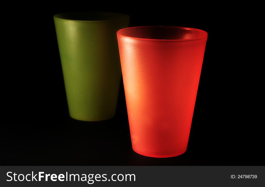 Red and green plastic glasses over black. Red and green plastic glasses over black