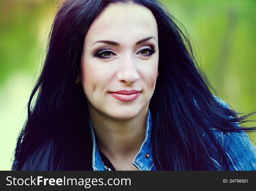 Beautiful brunette in the park looking left