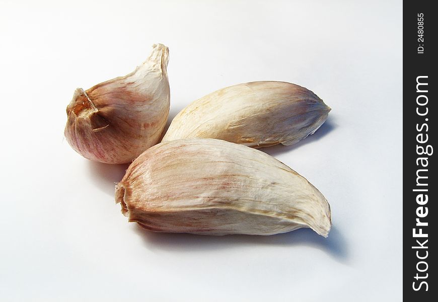 Three garlic cloves on a white background