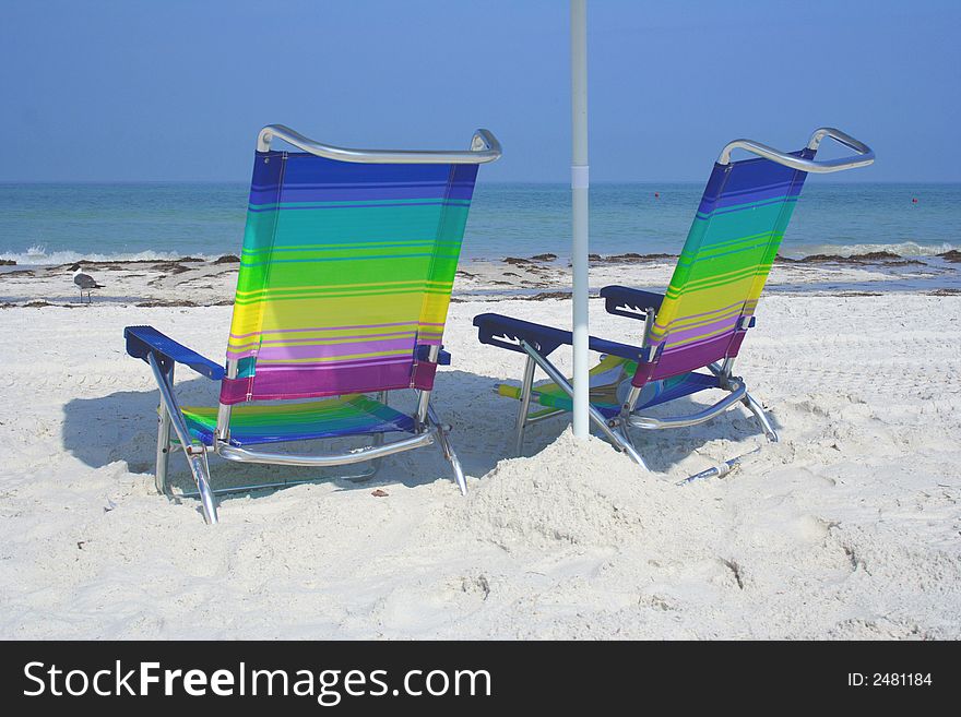 Two colorful chairs on the white sand. Two colorful chairs on the white sand