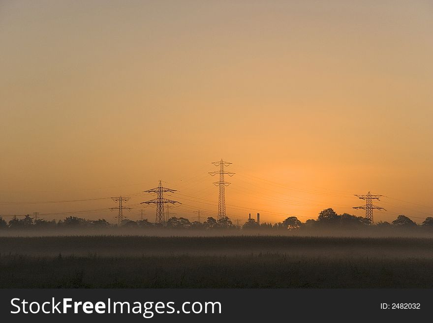 Sunrise with powerlines in front. A modern landscape. Sunrise with powerlines in front. A modern landscape