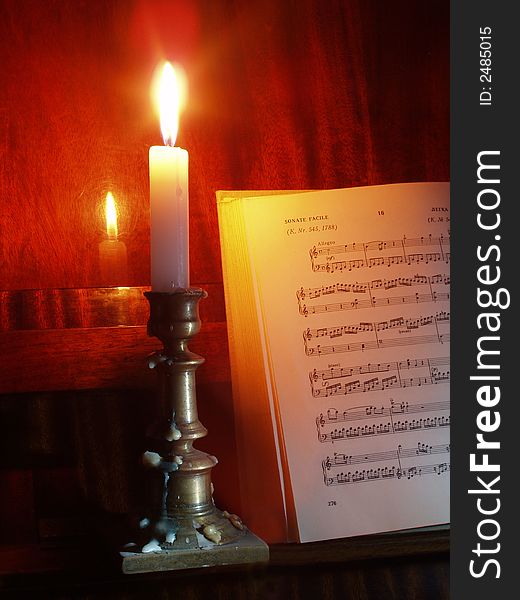 Retro still life with sheet music and piano at candle light
